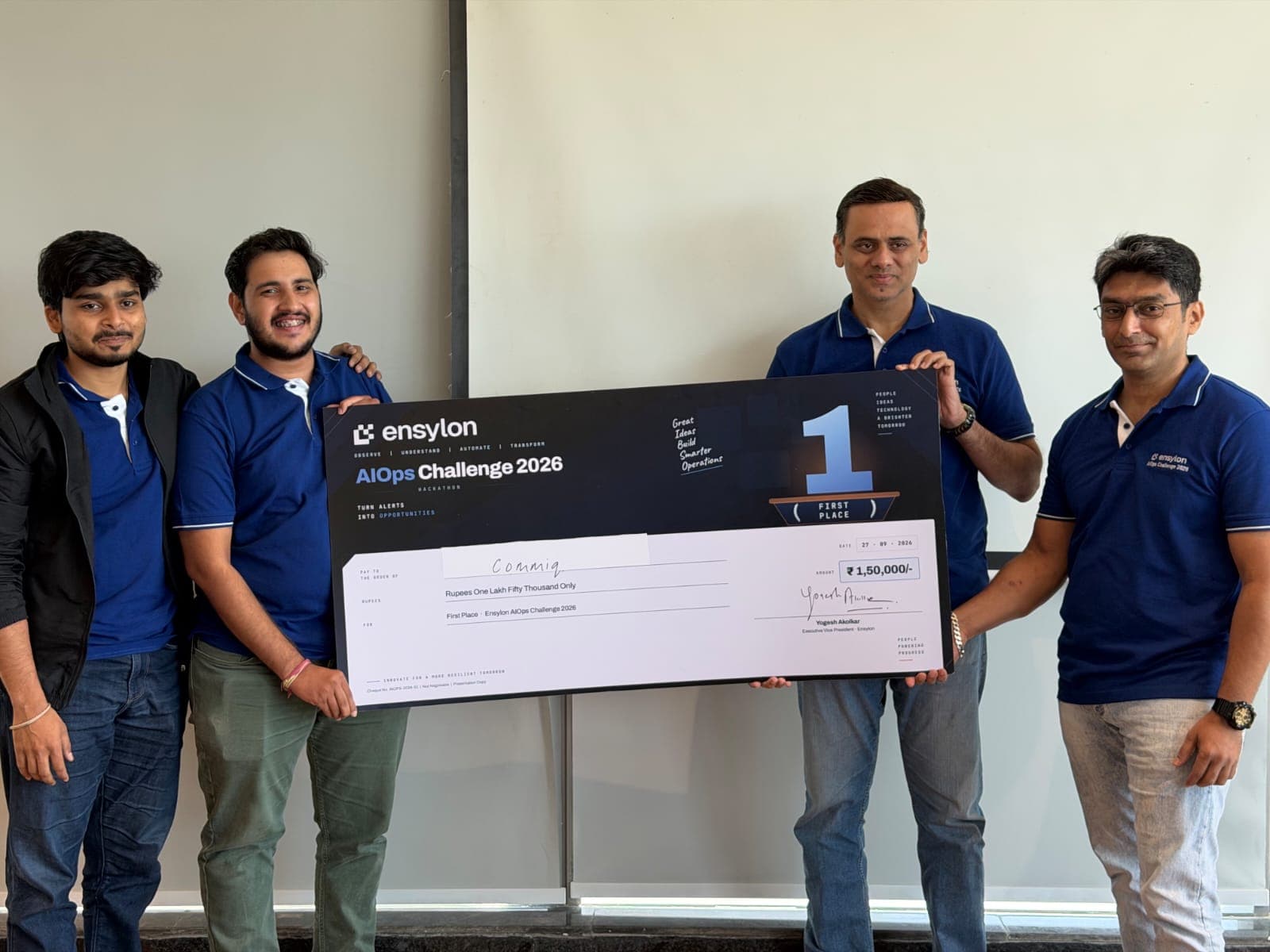 Team CommIQ holding the ₹1,50,000 first-place cheque with the Ensylon AIOps Challenge 2026 organisers